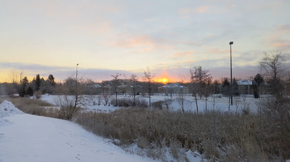 Picture of the sun rising over a snowy plain.