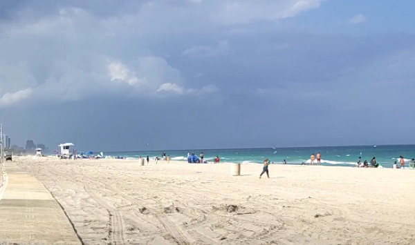 Picture of the beach with dark clouds overhead.