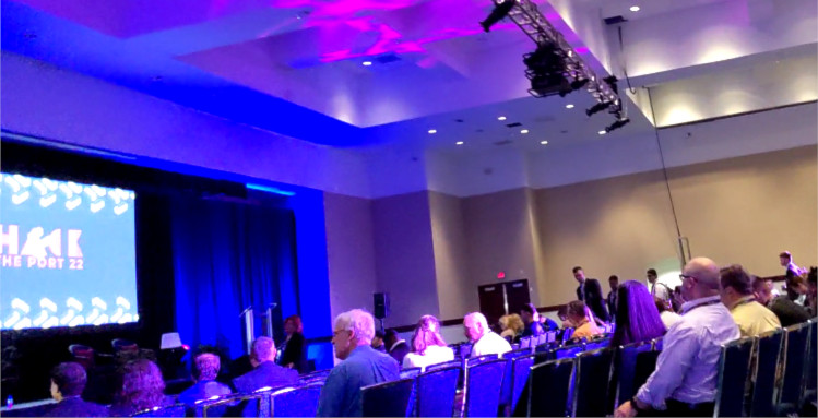 Speaker stage with purple and blue lighting.